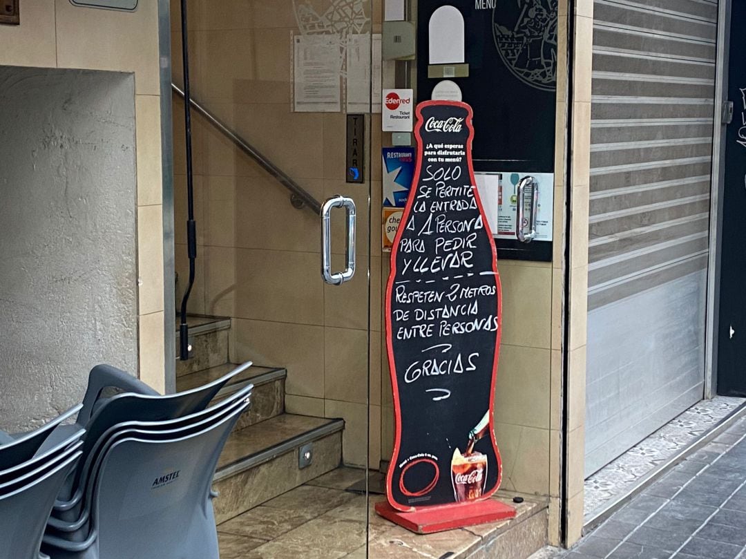 Cartel frente a un restaurante en València que abre solo con comida para llevar