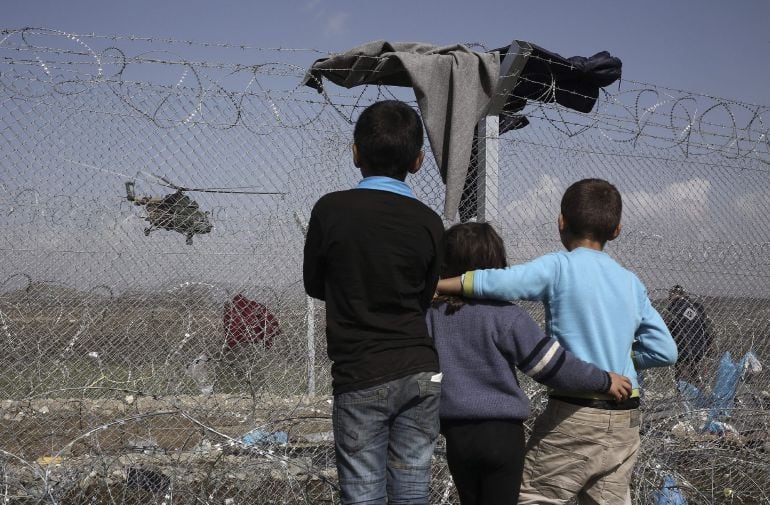 Un grupo de niños observa un helicóptero desde el campamento de refugiados en Idomeni (2015)