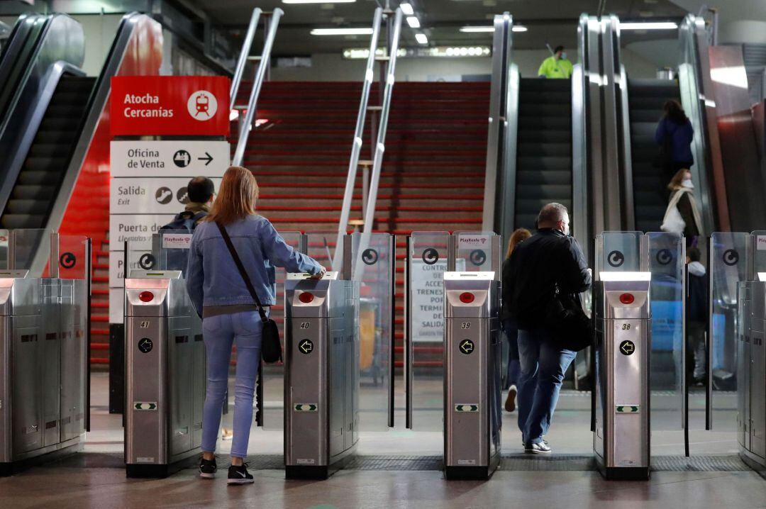 Varios usuarios acceden a la estación de Cercanías de Madrid-Atocha a primera hora de este lunes.