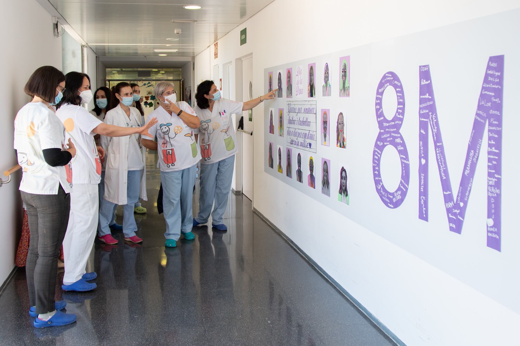 Profesionales del servicio de Pediatría del Hospital de Dénia junto al mural elaborado por sus pacientes.