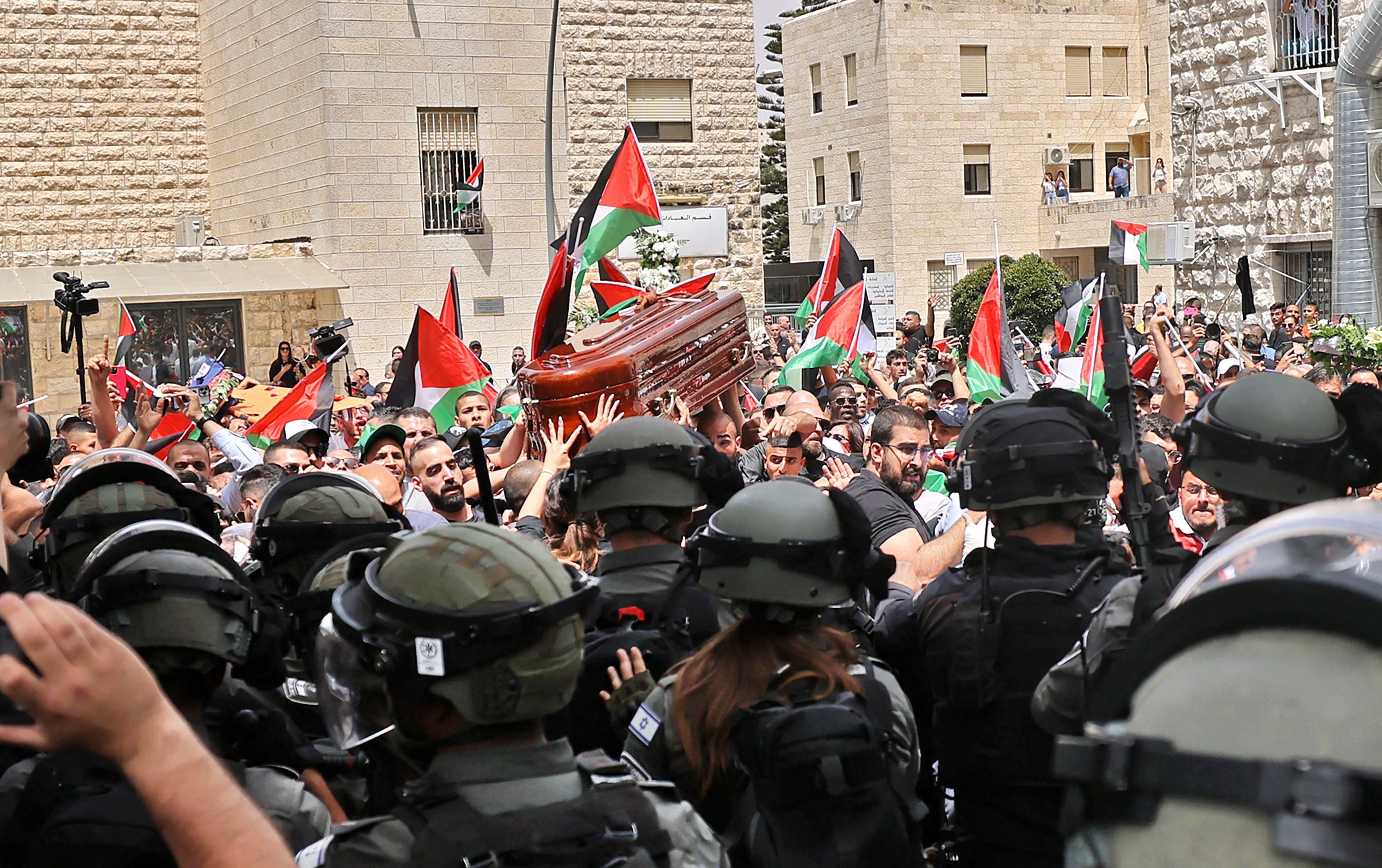 Varios hombres portan el ataúd de la periodista de Al Jazeera Shireen Abu Akleh, asesinada el pasado 11 de mayo, mientras la policía israelí carga contra ellos