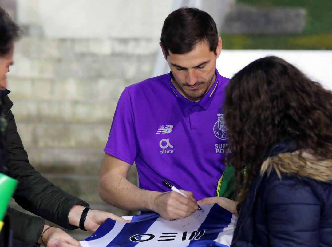 Iker Casillas firmando la camiseta de una aficionada del Porto