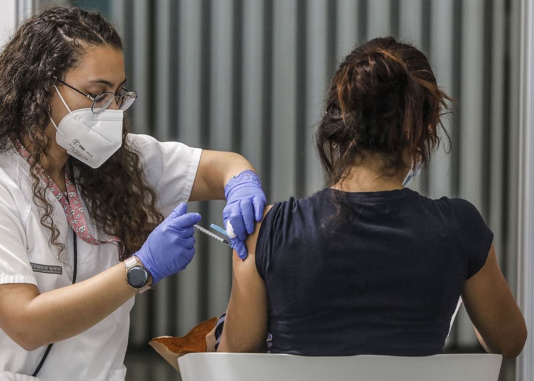 Una joven recibe la vacuna contra el covid-19 en el dispositivo puesto en marcha en la Ciutat de les Arts i les Ciències de València.