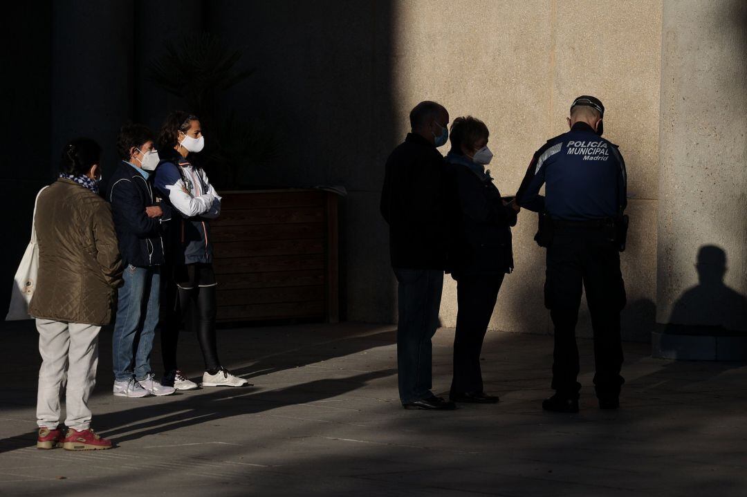 Varias personas esperan en las inmediaciones del Centro Municipal de Mayores Príncipe de Asturias, en la zona de salud básica de Doctor Cirajas, en Ciudad Lineal, a realizarse test de antígenos, en Madrid (España)