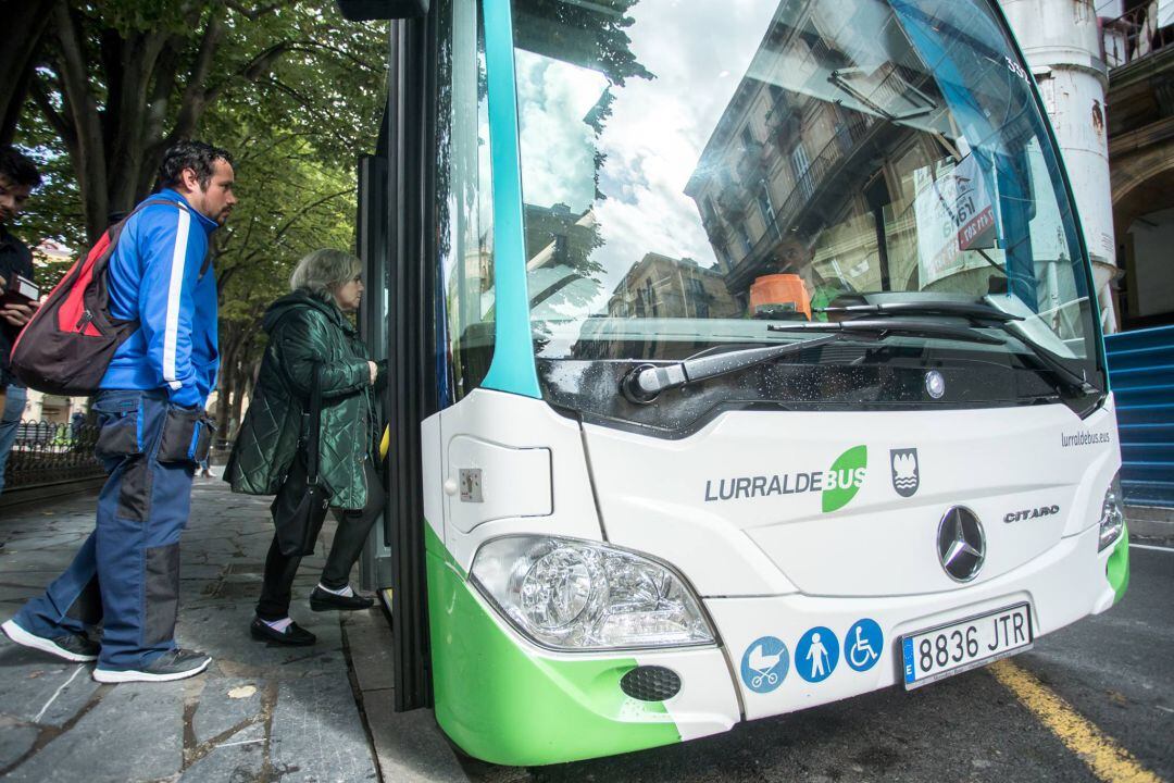 Varias personas suben a un autobús de Lurraldebus. 