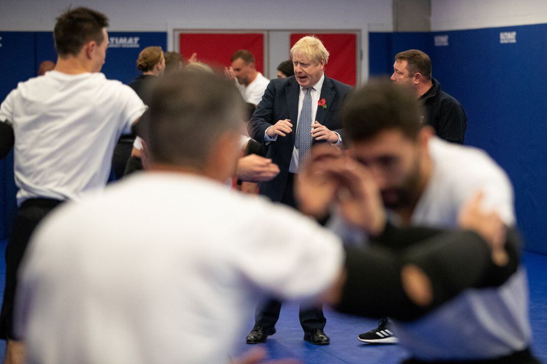 El primer ministro Boris Johnson observa una clase de defensa personal durante una visita al colegio de entrenamiento de la Policía Metropolitana en Hendon, Londres