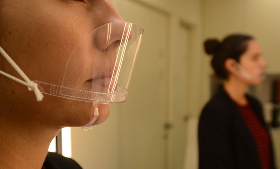 Una mujer con una mascarillas transparente de PVC.
