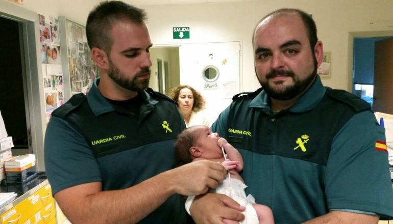 GRA266 MADRID, 15/07/2015.- Imagen cedida por la Guardia Civil de los dos agentes del instituto armado que han rescatado al recién nacido que había sido arrojado al interior de un contenedor de basura soterrado de Mejorada del Campo. EFE