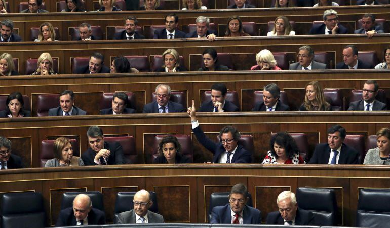 El diputado del PP Carlos Floriano (4d, segunda fila) marca el sentido del voto a sus compañeros de partido, durante el pleno que se celebra esta tarde en el Congreso de los Diputados. 