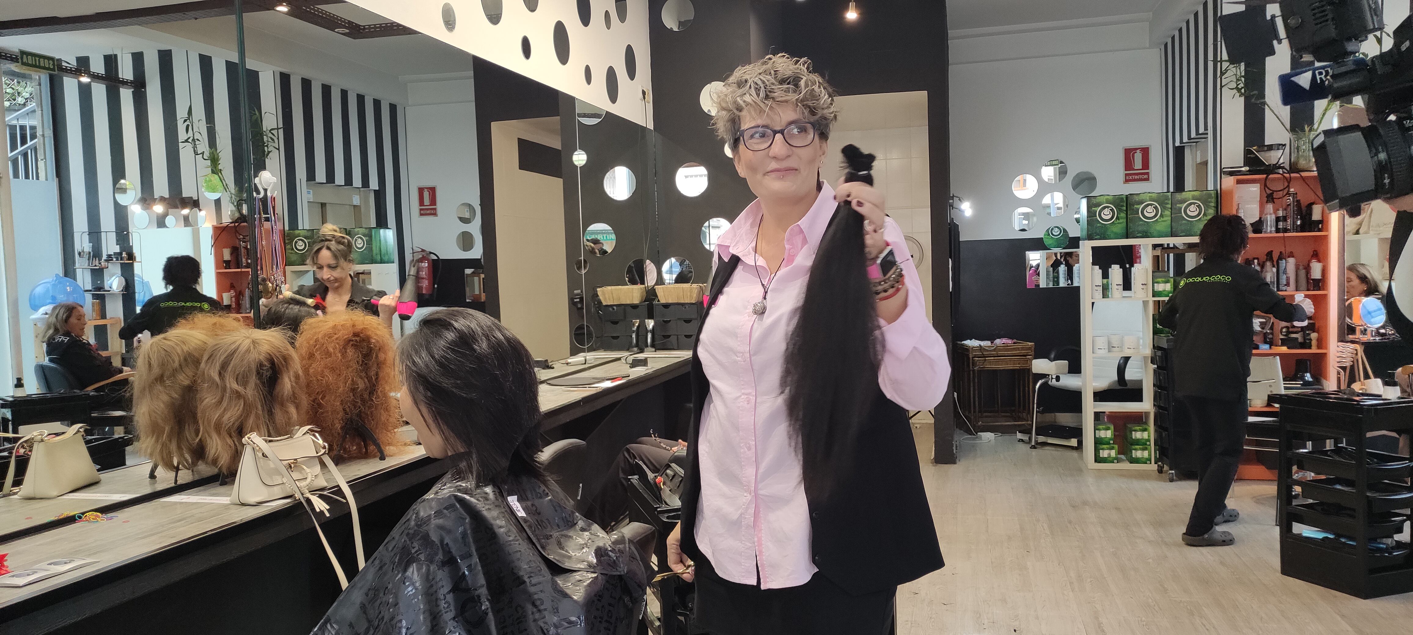 Nelly Garcia talla el cabell a una donant de perruques solidàries