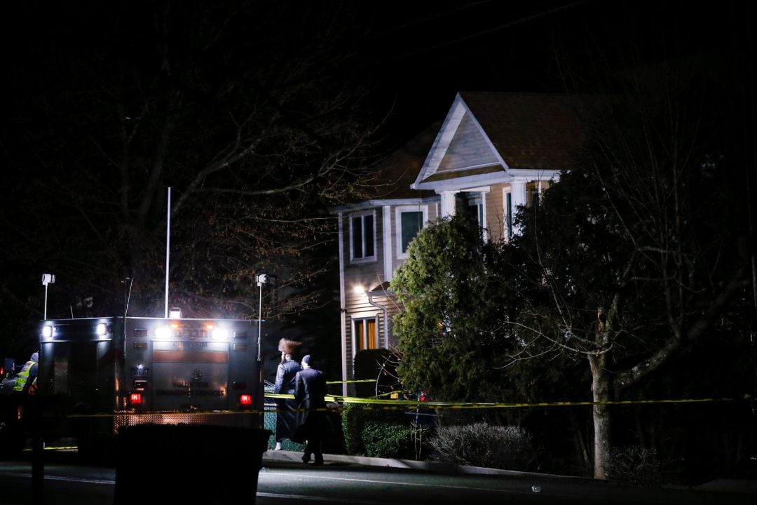 Algunas personas caminan frente a la casa en la que un hombre ha apuñalado esta madrugada a cinco personas en Nueva York, Estados Unidos.