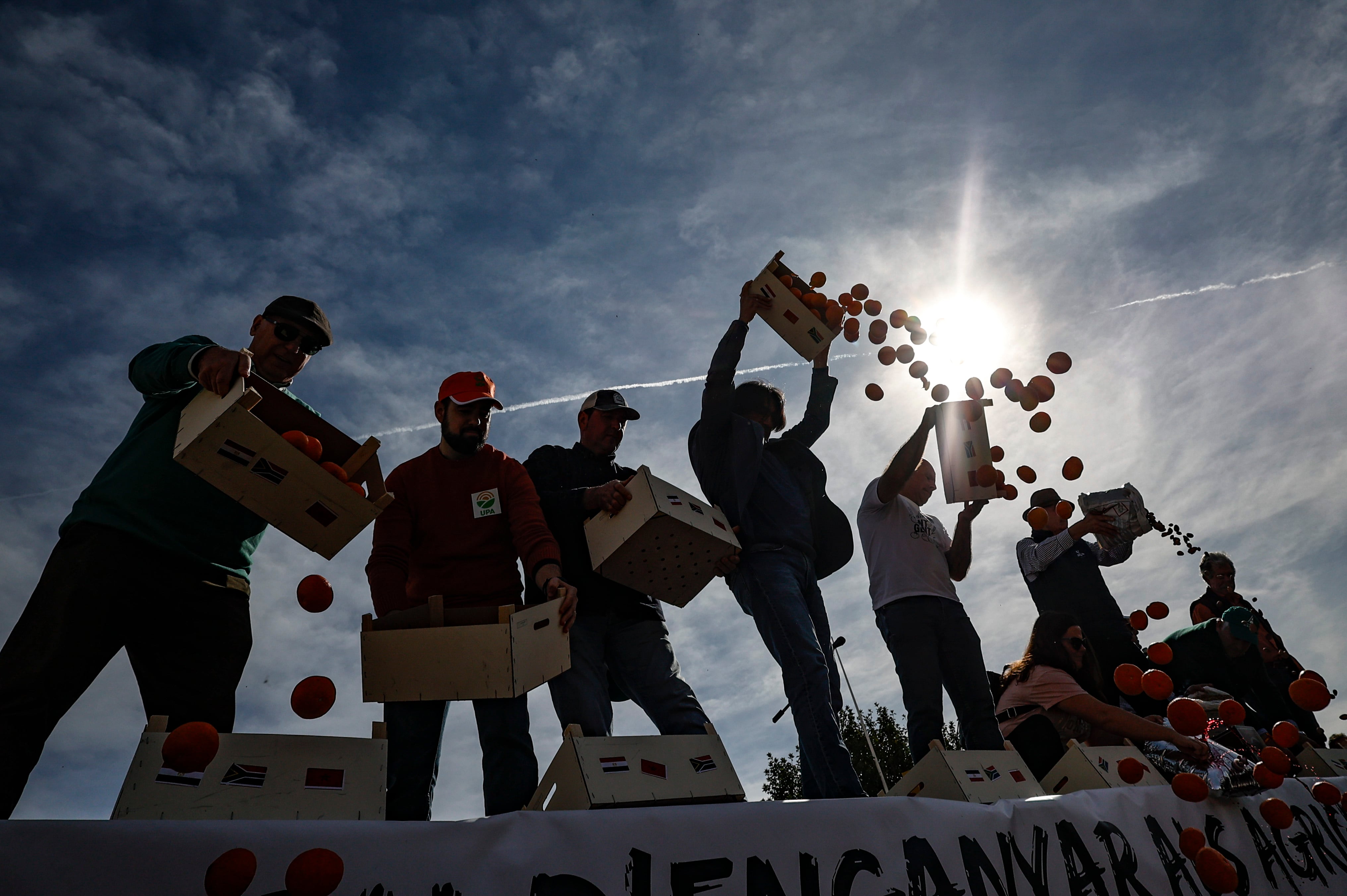 GRAFCVA8477. VALENCIA, 22/02/2024.- Decenas de tractores entran en València para concentrarse en el Puerto en la tercera protesta conjunta de las principales organizaciones agrarias, con el apoyo de las cooperativas, para reclamar un giro de las políticas a la Generalitat, el Gobierno y la Unión Europea, la preferencia comunitaria, la reciprocidad con las importaciones de países terceros y unos controles eficaces para evitar la entrada de nuevas plagas y enfermedades. En la imagen los agricultores arrojan verduras al suelo durante la concentración. EFE/Biel Aliño
