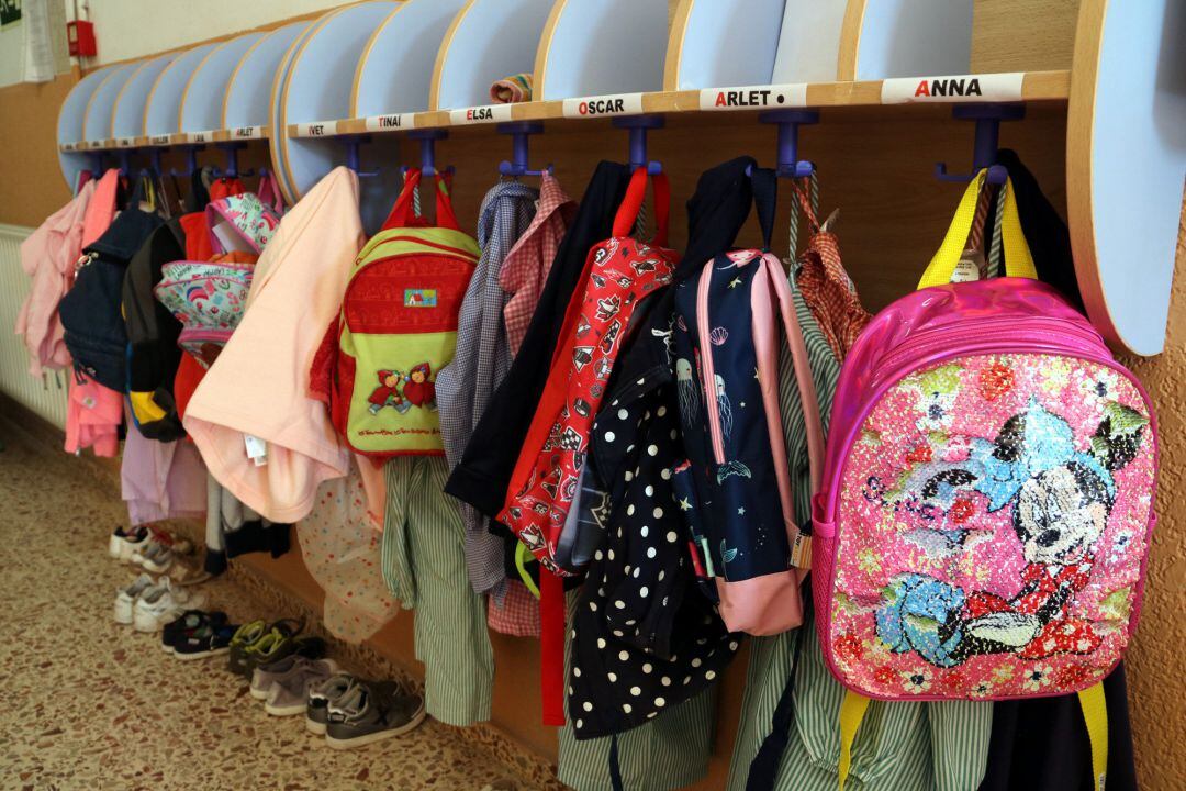 Motxilles i bates penjades en un passadís