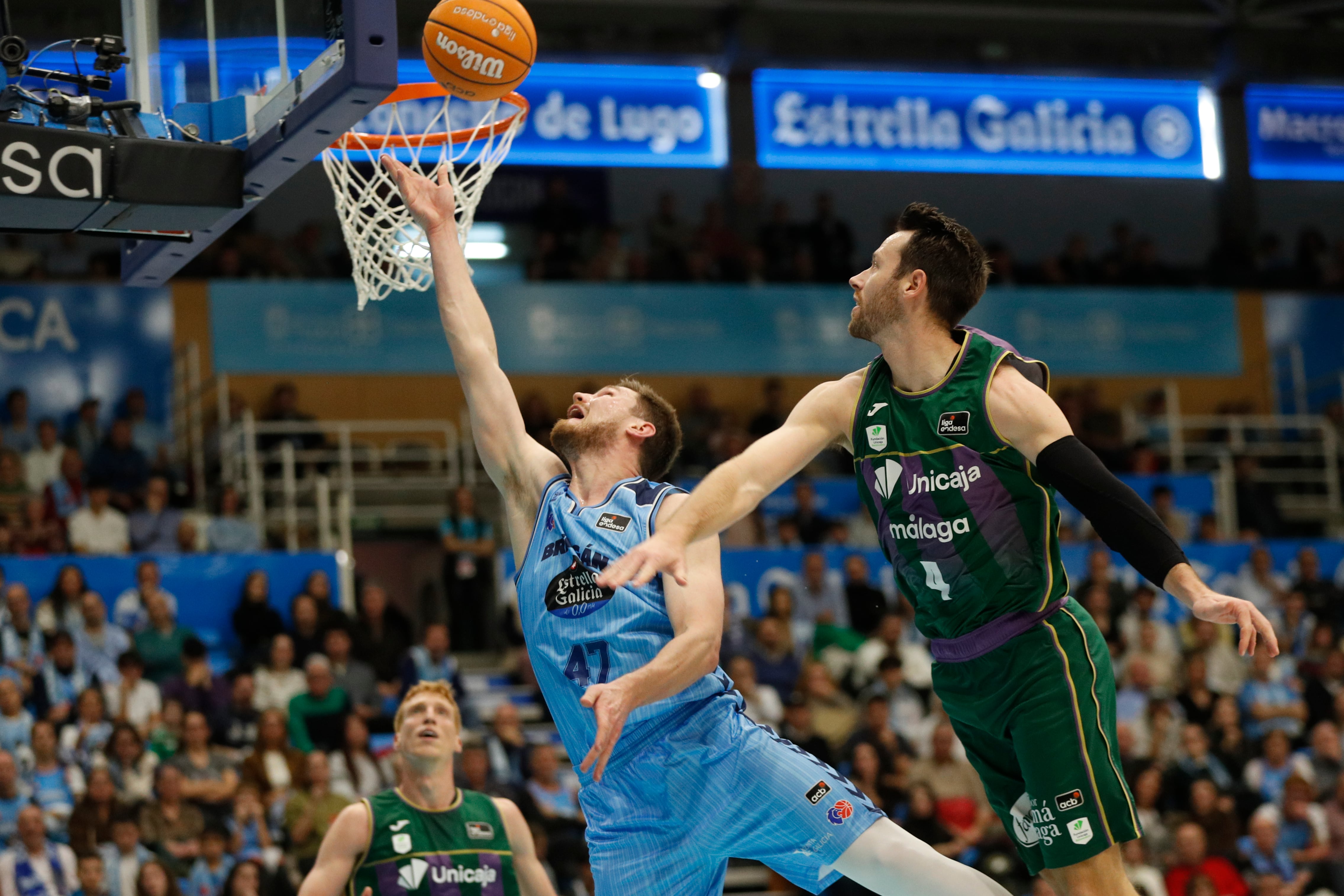 LUGO, 03/01/2026.- El escolta estadounidense del Unicaja Málaga Tyler Kalinoski (d) intenta taponar al escolta letón del Breogan, Arturs Kurucs, en el partido de Liga Endesa de baloncesto que disputan Breogan Lugo y Unicaja Málaga, este sábado en la capital lucense. EFE/ Eliseo Trigo