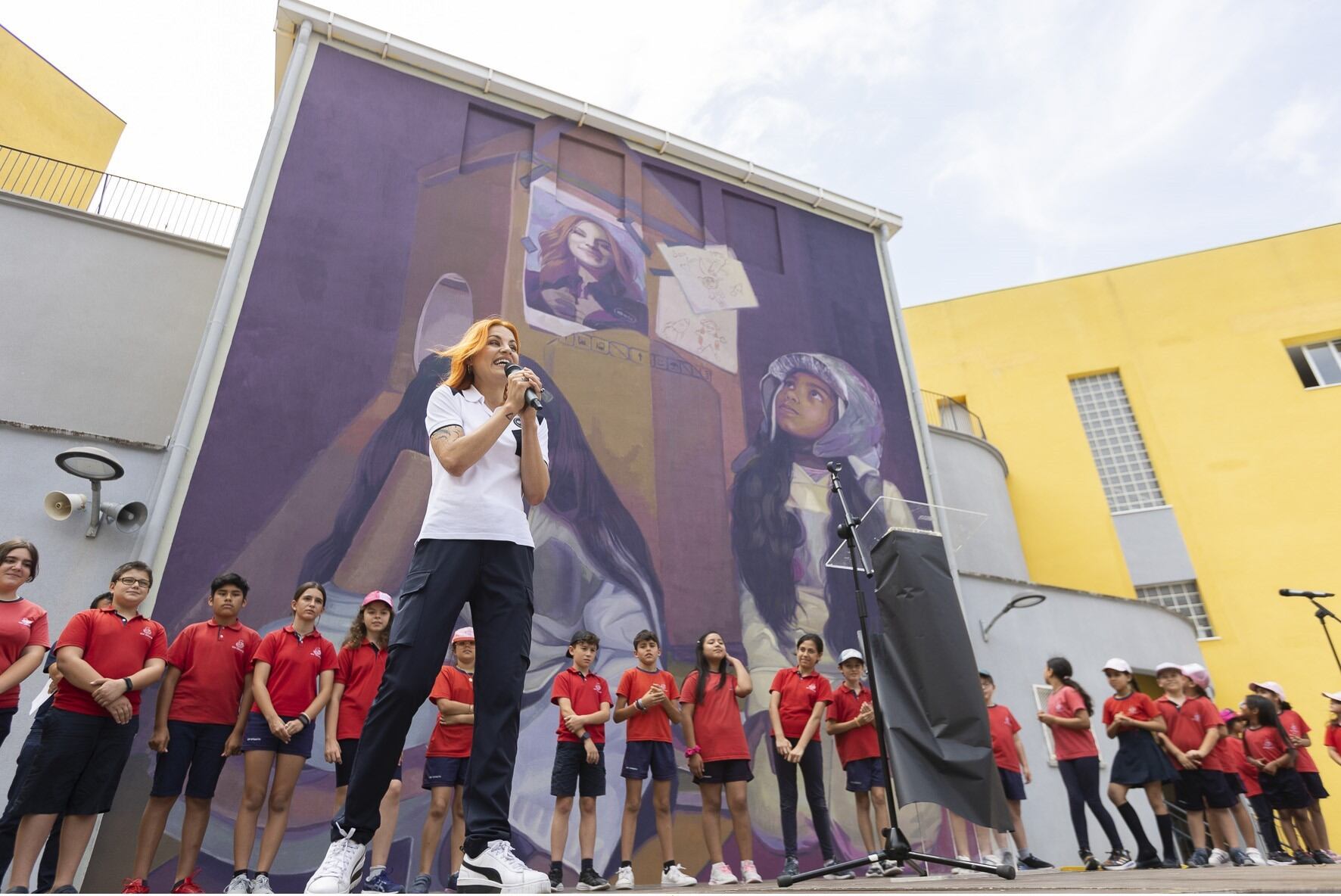 La astronauta Sara García junto a alumnado del colegio Cervantes, donde se ha pintado un mural en su nombre.