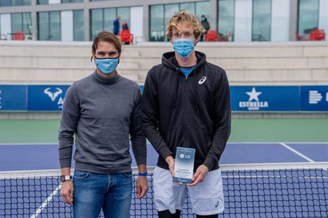 Rafa Nadal entrega al suizo Bellier el trofeo de campeón del ITF de la Academia.