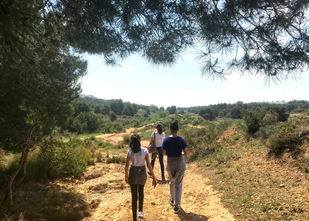 Tres personas caminan por el paraje natural de Les Moles