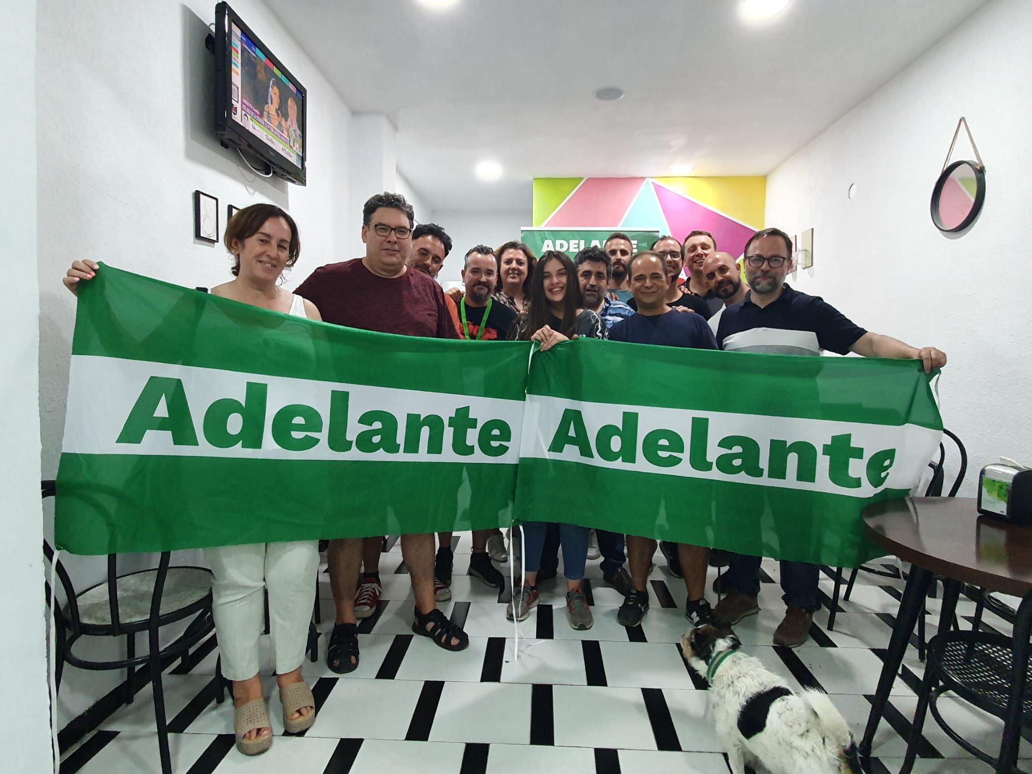 Representantes de Adelante Andalucía portan la bandera andaluza con el nombre de la formación en la noche electoral.