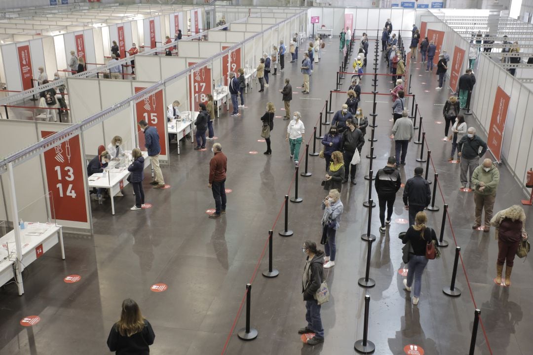 Decenas de personas esperan su turno para vacunarse en Alicante.
