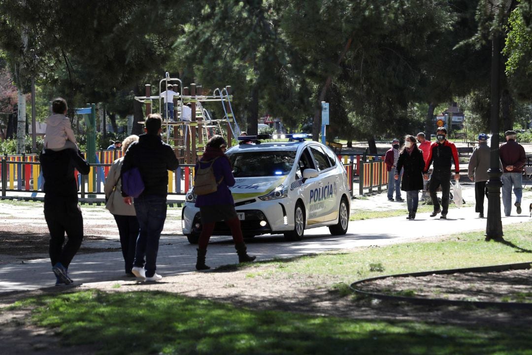 Un coche de la policía municipal patrulla por un parque en el madrileño barrio de Aluche, este sábado. Las restricciones de movilidad para tratar de contener la expansión del coronavirus decretadas por el Ministerio de Sanidad han entrado en vigor el pasado viernes a las 22:00 horas en diez municipios madrileños, entre ellos Madrid, que suman cerca de cinco millones de habitantes.