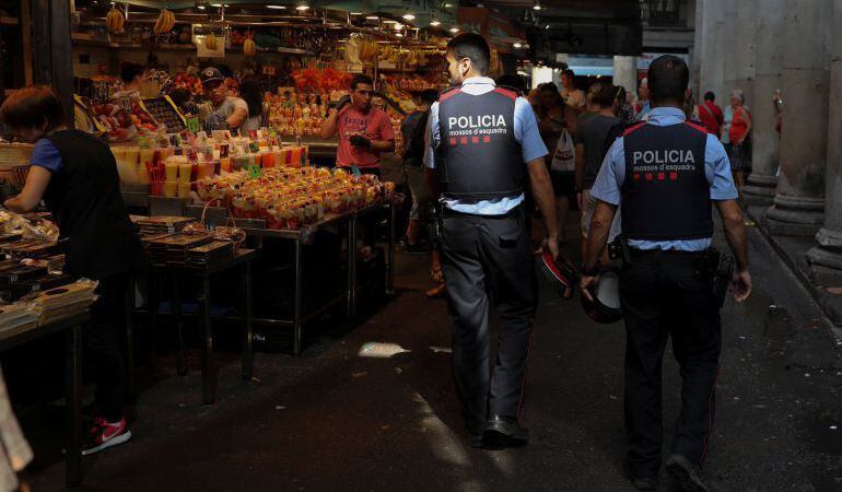 Dos Mossos patrullan por el mercado de la Boquería.