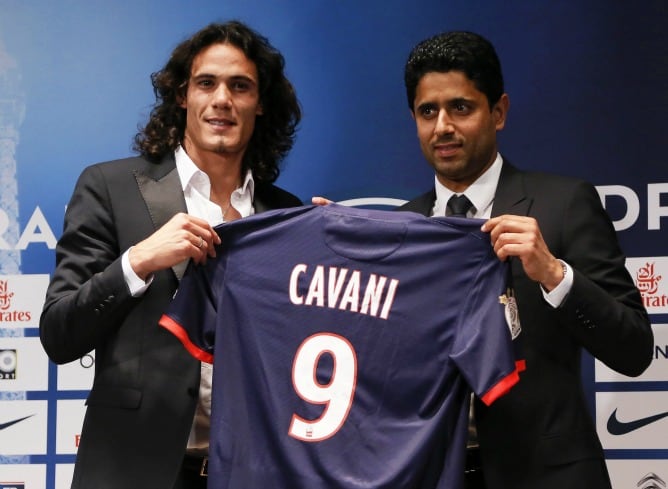 El nuevo delantero uruguayo del París Saint Germain (PSG), Edinson Cavani, posa con su nueva camiseta junto al propietario del club, Nasser al-Khelaifi, durante una rueda de prensa ofrecida con motivo de la presentación del jugador en París, Francia. El P