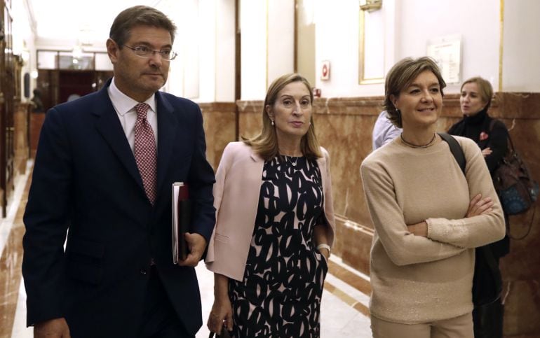 Los ministros de Fomento y Justicia, Rafael Catalá (i), y de Agricultura, Isabel García Tejerina (d), acompañados de la presidente del Congreso, Ana Pastor (c), a su salida tras el discurso del presidente del Gobierno en funciones y líder del PP, Mariano 