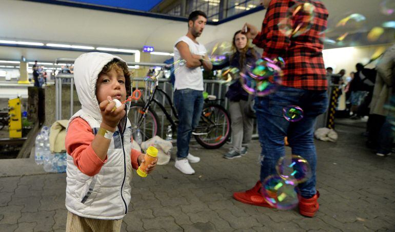 Un niño sirio juega con un pompero en la estación de trenes de Viena. 