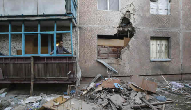 Un hombre mira a través de la ventana los daños causados por el bombardeo en Slaviansk, al este de Ucrania