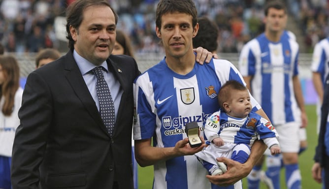 El jugador de la Real Sociedad, Mikel Aramburu, con su hijo, tras recibir de manos del presidente del club donostiarra, Jokin Aperribay , la insignia de oro y brillantes del club