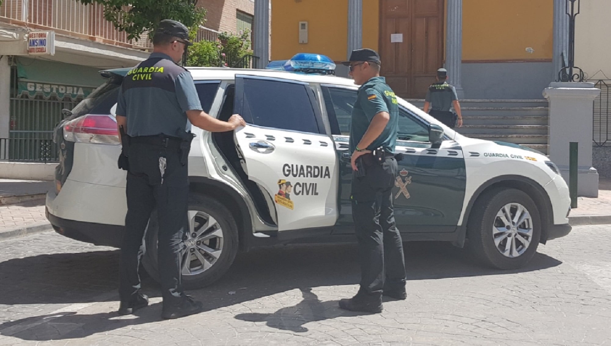 Agentes de la Guardia Civil abren la puerta del vehículo policial.