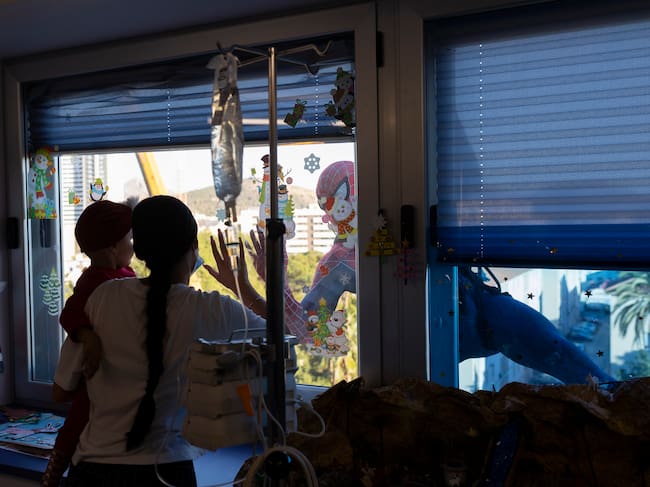 GRAFAND7546. MÁLAGA, 18/12/2023.- Spiderman se ha descolgado por la fachada del Hospital Materno de Málaga, desde el tejado con la ayuda de un bombero, para saludar a los niños ingresados en las plantas de enfermedades infecciosas, Oncología, Lactantes y Cirugía a través de las ventanas. EFE/Carlos Díaz