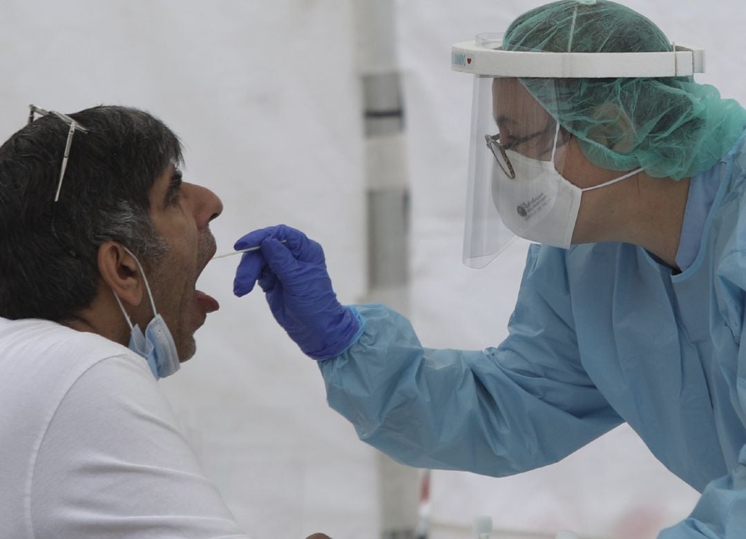 Una sanitaria le realiza un frotis bucal a un paciente.