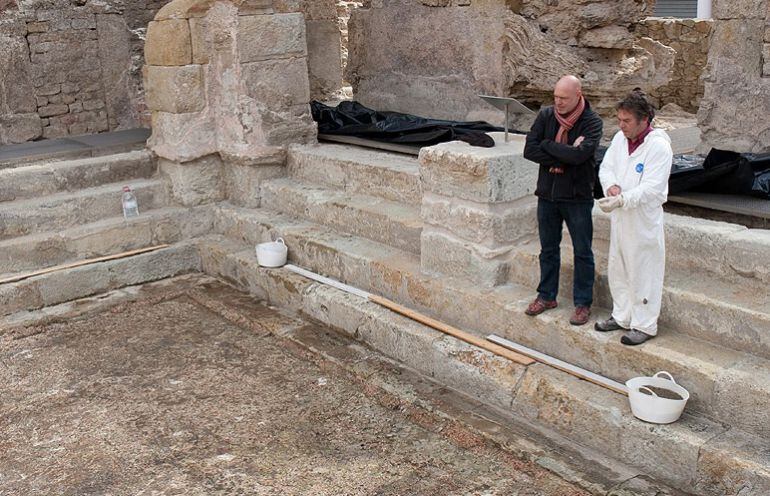 El regidor i el tècnic responsable de la restauració observant el treball.