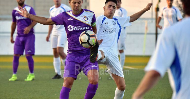 Dos futbolistas se disputan el balón durante el encuentro.