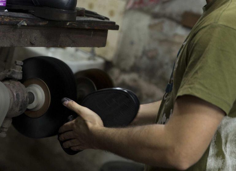 ACOMPAÑA CRÓNICA:BRASIL PRIMERO DE MAYO BRA01. RÍO DE JANEIRO (BRASIL), 01/05/2015.- Fotografía del 30 de abril de 2014 de Jonatas Hastemreiter, de 27 años trabajando en la zapatería de su familia. Ezequias Hastemreiter, un brasileño que aprendió a remendar y remozar calzados con su padre y vive de ello hace 36 años en Río de Janeiro, alega que los zapateros tienen poco que conmemorar hoy, en el Día del Trabajo, ya que se trata de un oficio en vía de extinción y cada vez peor remunerado. EFE/Marcelo Sayão