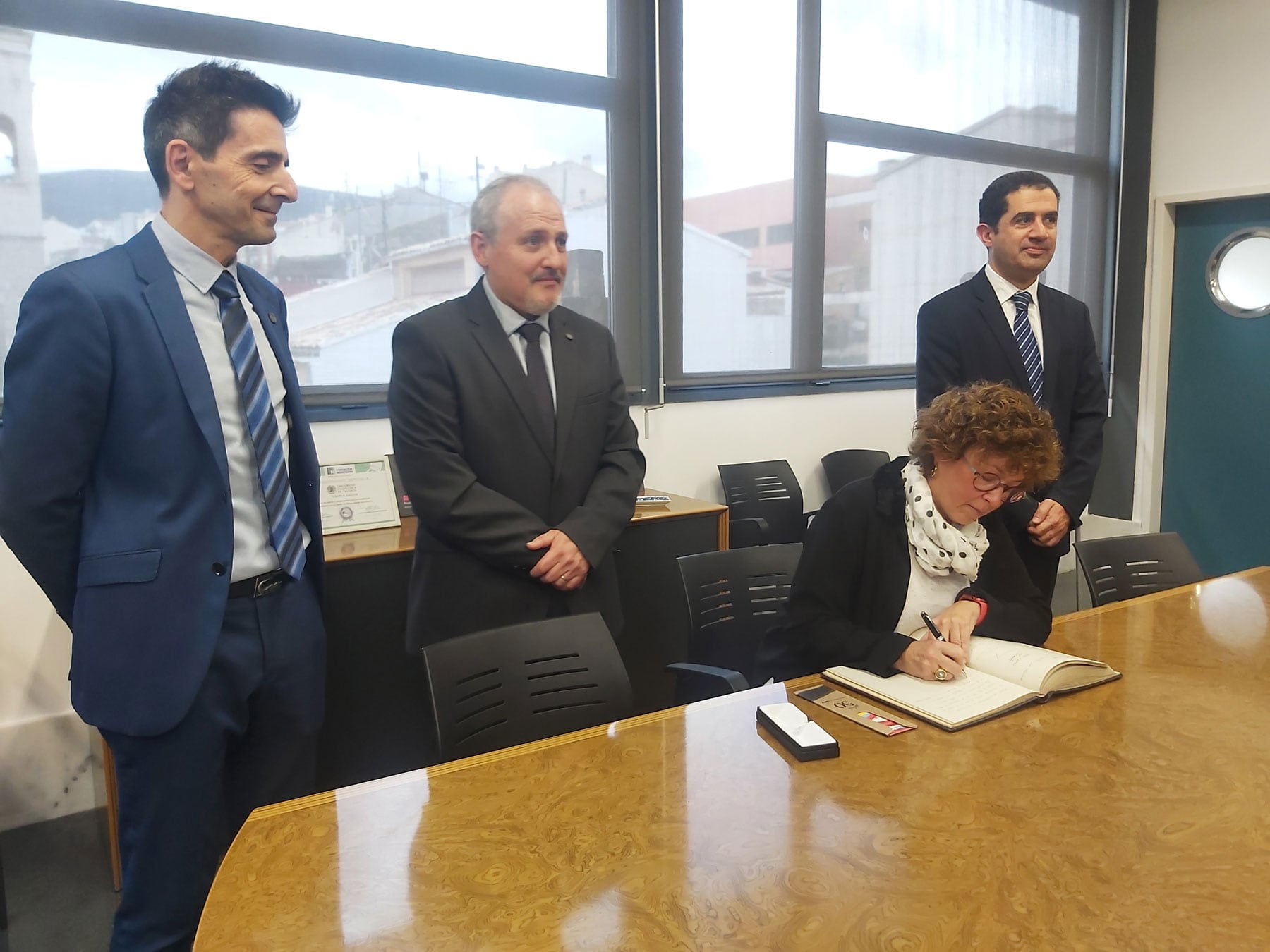 Salvador Coll, Pau Bernabeu y Toni Francés, mientras la consellera Josefina Bueno firma en el libro de oro del Campus