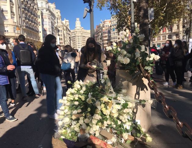 Asistente al minuto de silencio coloca la flor enfrente del Ayuntamiento