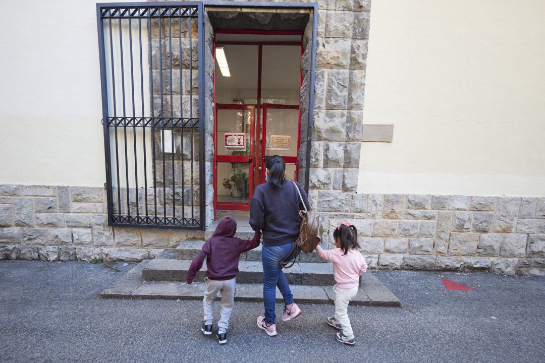 Archivo - Una madre lleva a sus hijos al Colegio