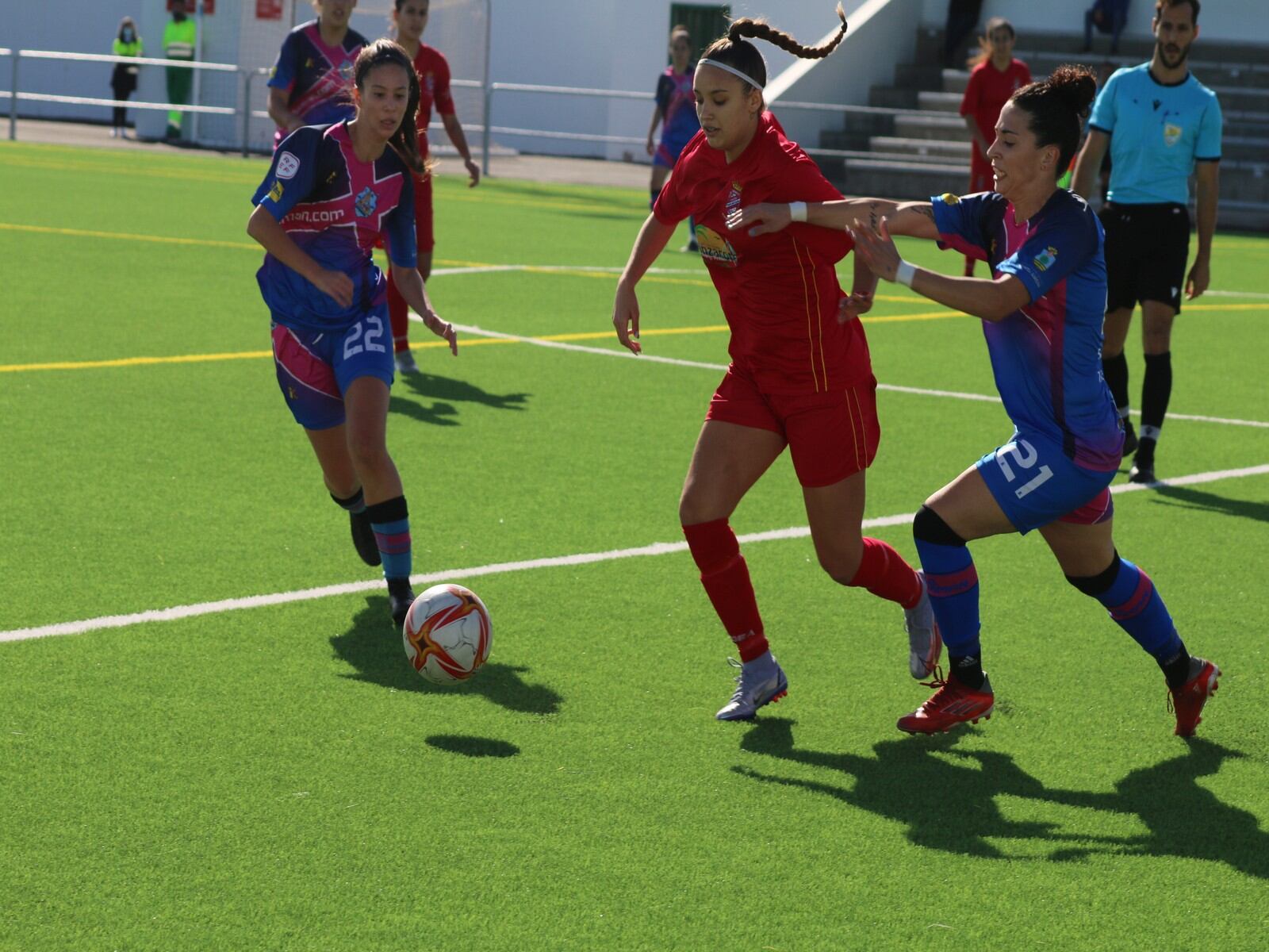 Una de las lanzaroteñas conduciendo el balón ante dos contrarias.