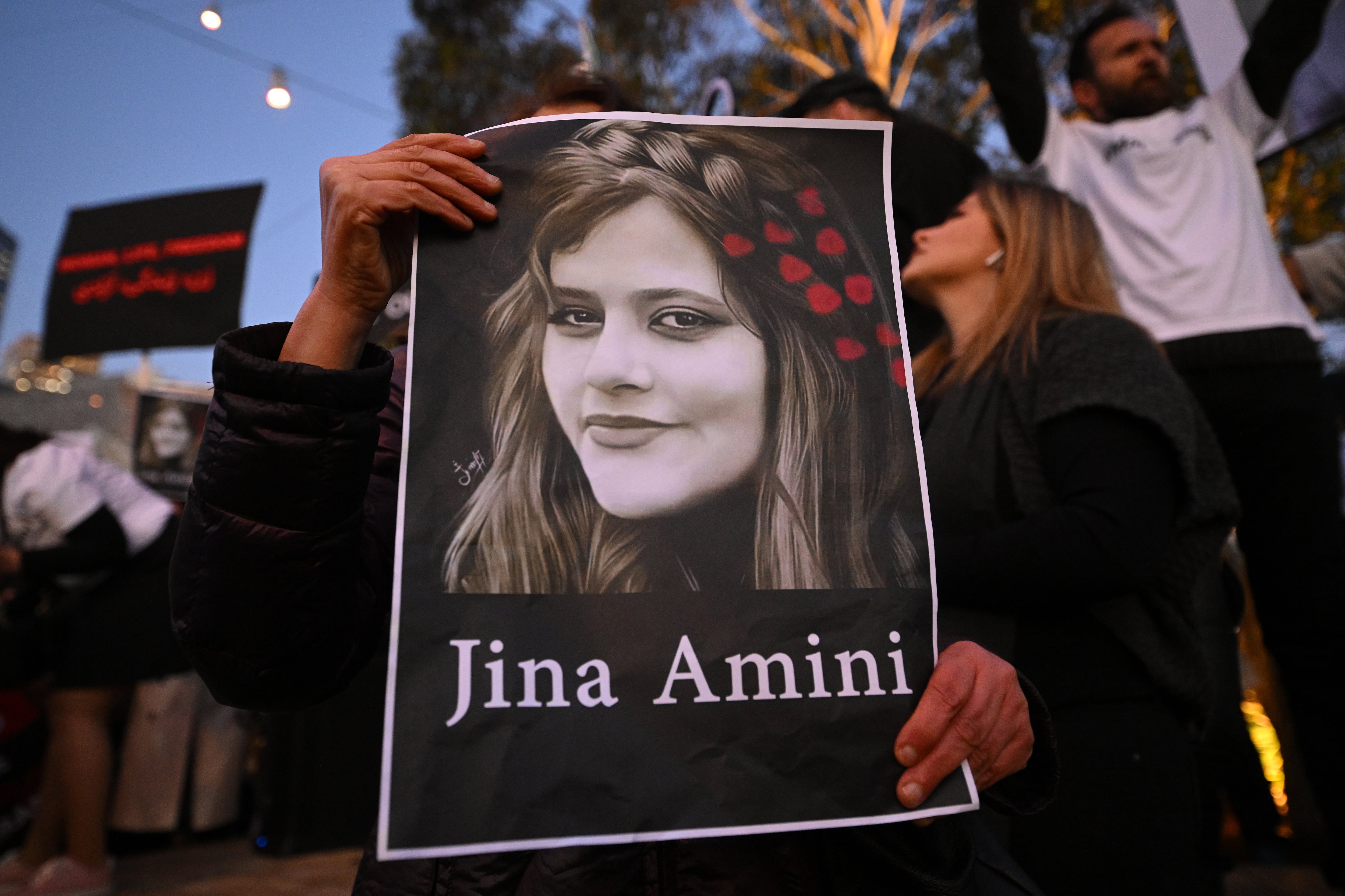 Melbourne (Australia), 29/09/2022.- A protester holds a placard picturing Masha Amini during a demonstration following the death of Mahsa Amini in Iran, at Federation Square in Melbourne, Victoria, Australia, 29 September 2022. Protests have continued to rage in Iran over the death in custody of Mahsa Amini, with demonstrators calling for the end of clerical rule. (Protestas) EFE/EPA/JAMES ROSS AUSTRALIA AND NEW ZEALAND OUT
