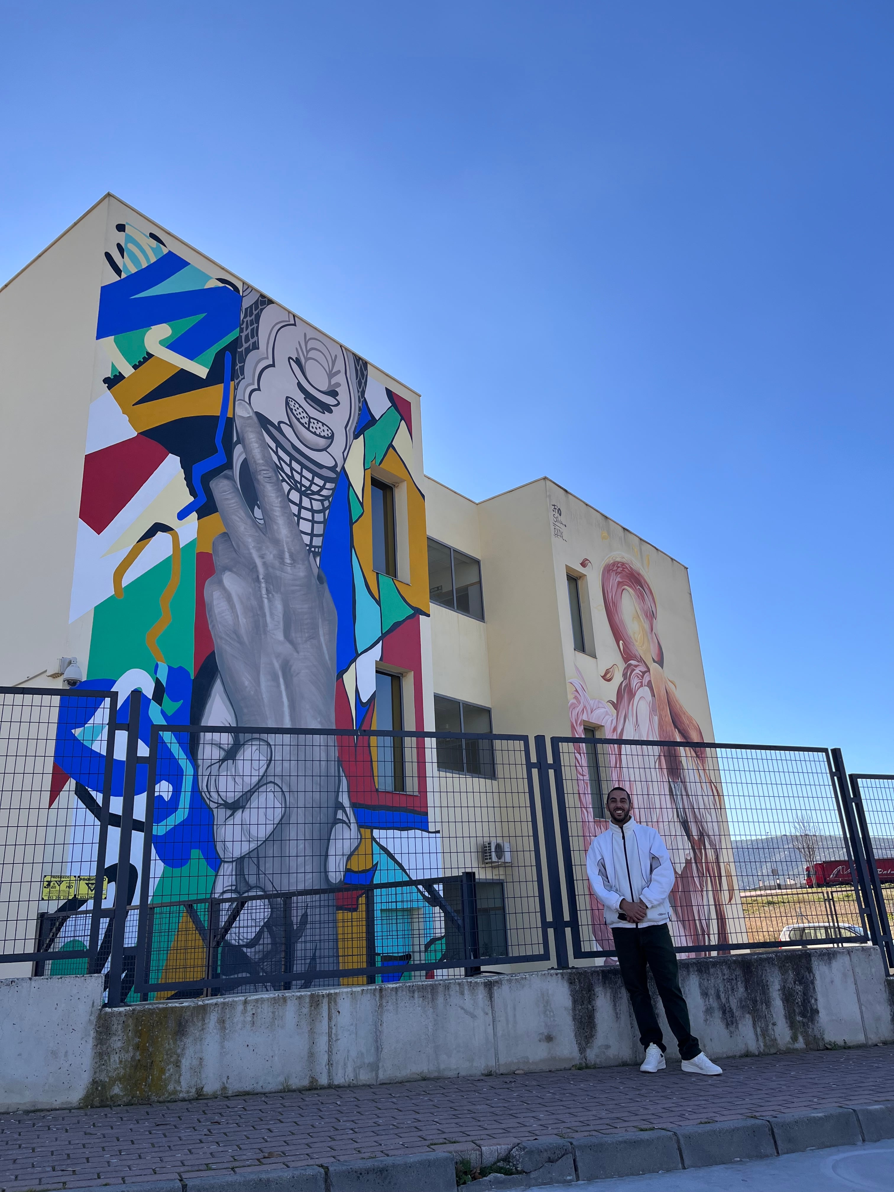 Sake posando frente al mural que acaba de ganar el premio a Mejor del mundo en 2024.