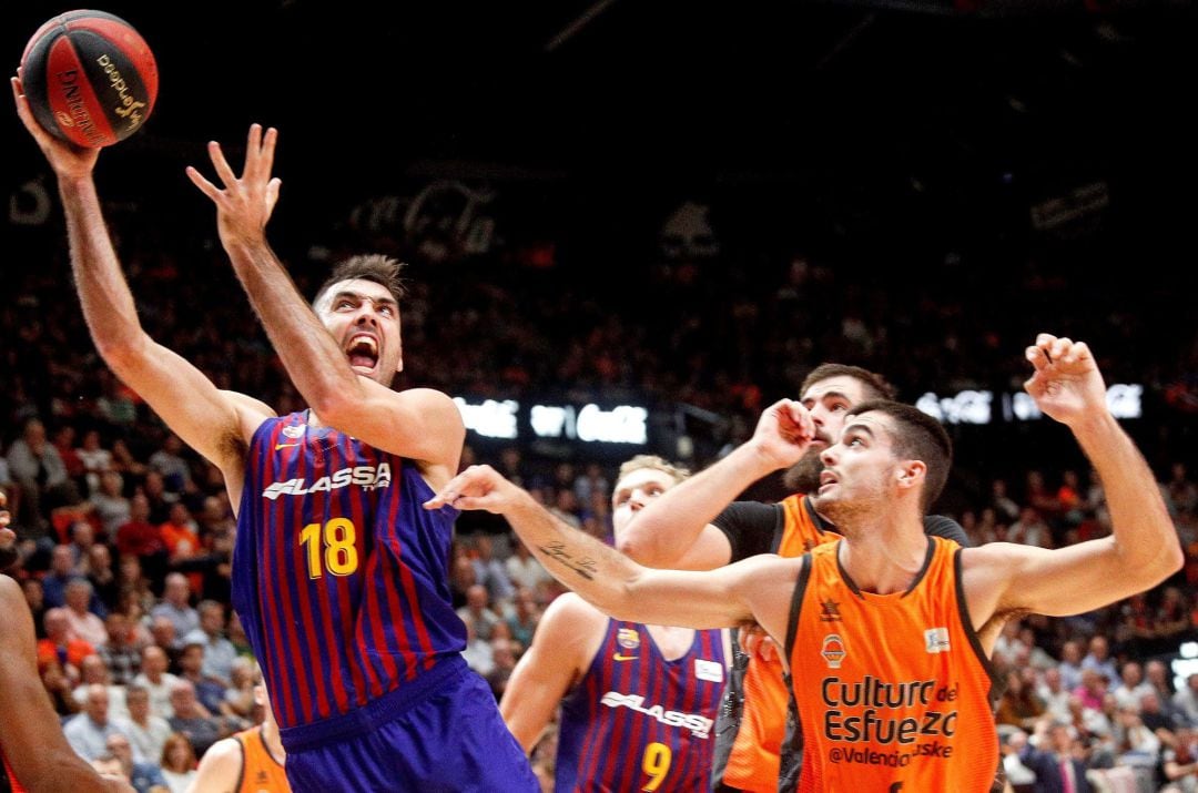 El escolta del Barca Lassa, Pierre Oriola con el balón ante el alero de Valencia Basket, Alberto Abalde