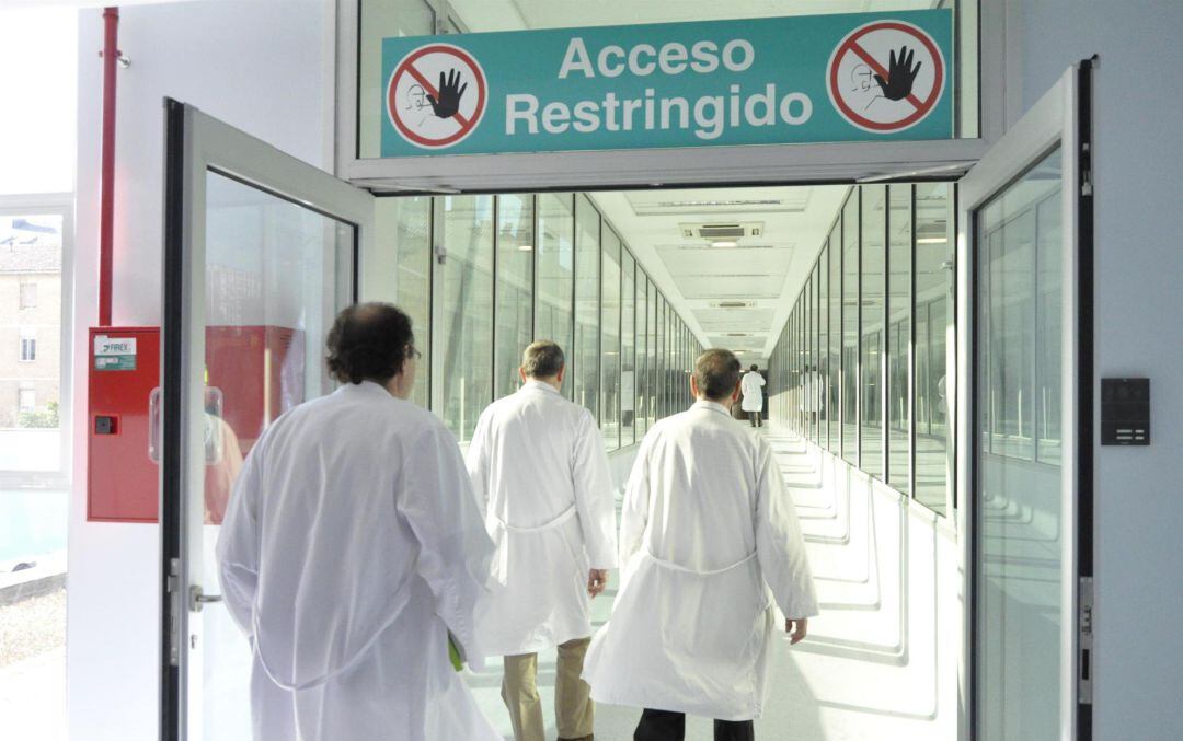 Tres profesionales sanitarios acceden a un área restringida de un hospital.