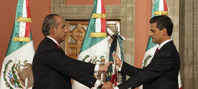 El mandatario saliente, Felipe Calderón, entrega la bandera de México a Peña Nieto, en el acto de investidura del nuevo presidente