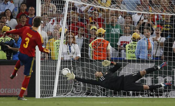 El jugador de España Gerard Piqué (i) anota un gol de penalti en la ronda de tiros ante Portugal, miércoles 27 de junio de 2012, en la semifinal de la Eurocopa 2012 en Donetsk (Ucrania). España ganó y es finalista del torneo