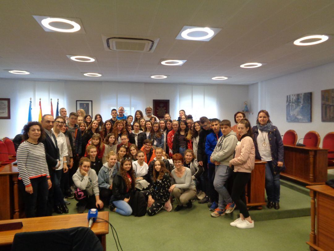 Estudiantes y profesoras posan en el salón de plenos con algunos representantes municipales