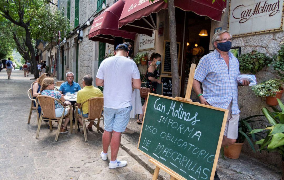 Vista de carteles en la pastelería de Valldemosa este jueves en Palma de Mallorca que informan de la obligatoriedad de mascarillas en todos los espacios públicos y de acceso público sin importar si se puede respetar la distancia de seguridad sanitaria, excepto en playas, piscinas, cuando se esté consumiendo comida o bebida o se practique deporte. 