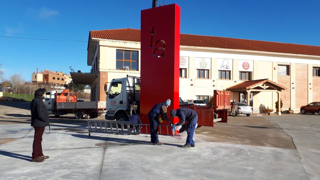 Delso, a la izquierda, asiste a la instalación de su escultura