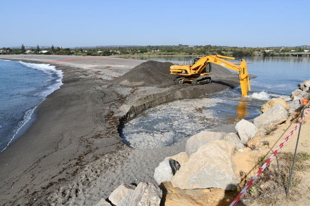 Una excavadora abre la bocana del río.